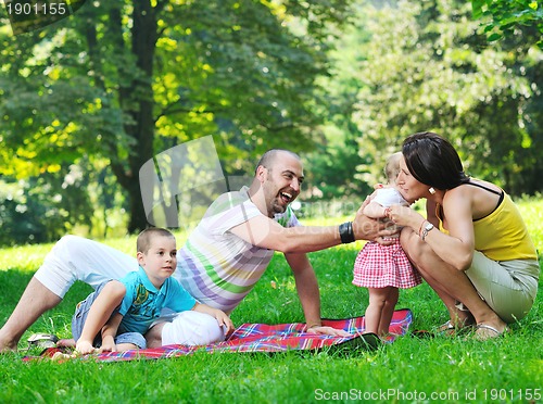 Image of happy young couple with their children have fun at park