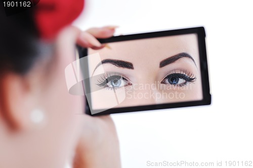 Image of beautiful young woman applying makeup