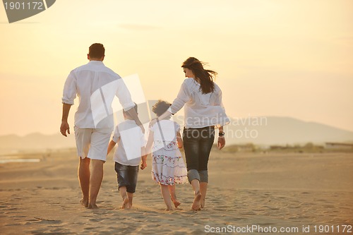 Image of happy young family have fun on beach at sunset
