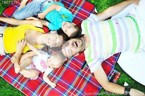 Image of happy young couple with their children have fun at park