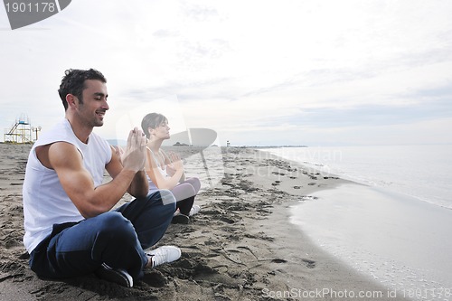 Image of couple yoga beach