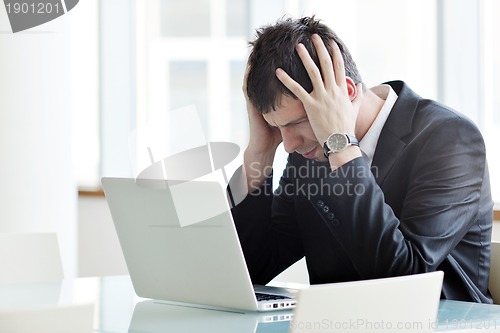 Image of young business man alone in conference room