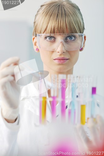 Image of female researcher holding up a test tube in lab