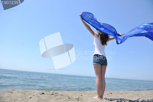 Image of beautiful young woman on beach with scarf