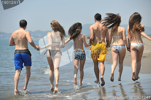 Image of happy people group have fun and running on beach