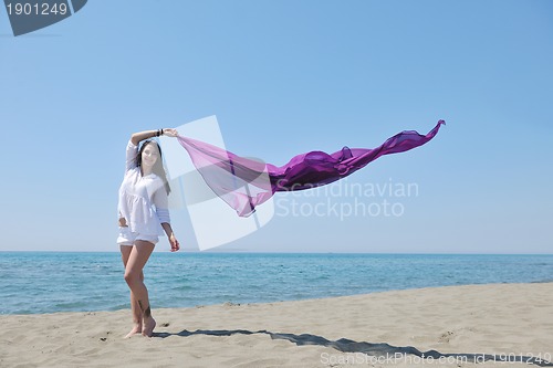 Image of beautiful young woman on beach with scarf