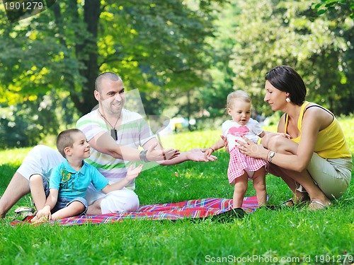 Image of happy young couple with their children have fun at park