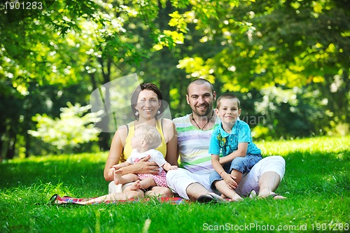 Image of happy young couple with their children have fun at park