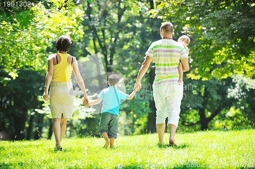 Image of happy young couple with their children have fun at park
