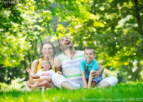 Image of happy young couple with their children have fun at park