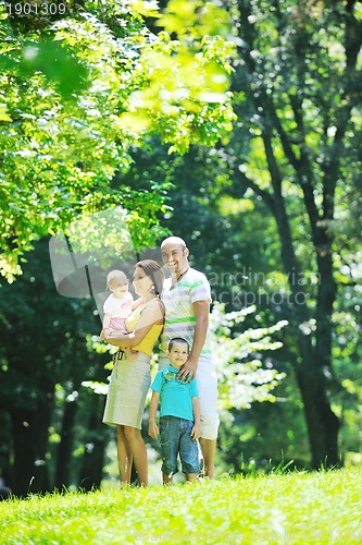Image of happy young couple with their children have fun at park