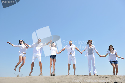 Image of happy people group have fun and running on beach