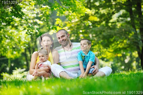 Image of happy young couple with their children have fun at park