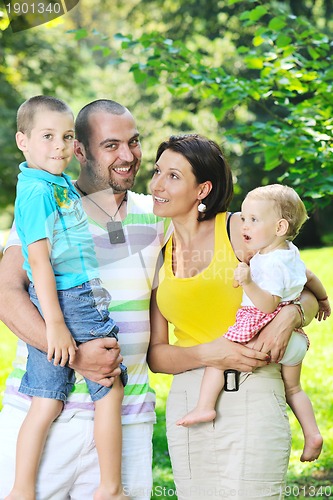 Image of happy young couple with their children have fun at park