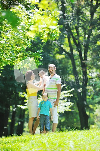 Image of happy young couple with their children have fun at park
