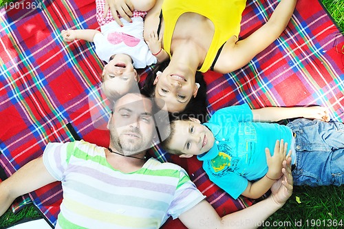 Image of happy young couple with their children have fun at park