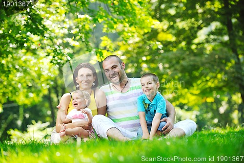 Image of happy young couple with their children have fun at park