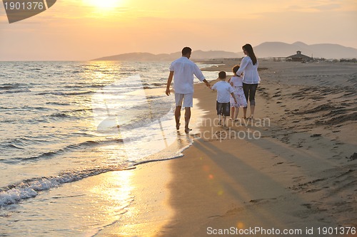 Image of happy young family have fun on beach at sunset