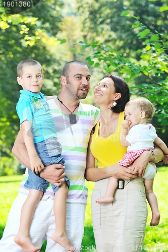 Image of happy young couple with their children have fun at park