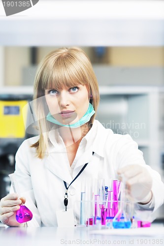 Image of female researcher holding up a test tube in lab