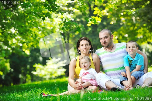Image of happy young couple with their children have fun at park