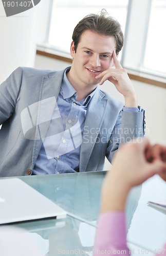 Image of young business man alone in conference room