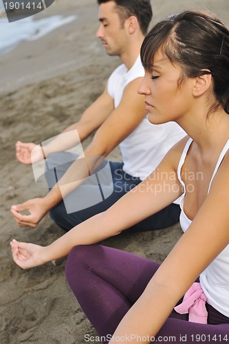 Image of couple yoga beach