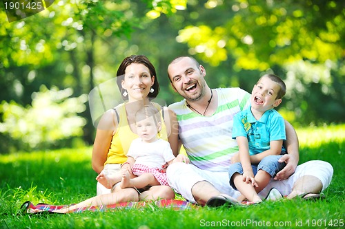 Image of happy young couple with their children have fun at park