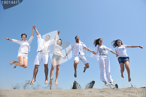 Image of happy people group have fun and running on beach