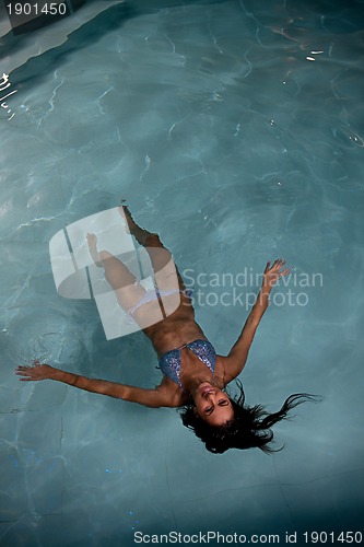 Image of pretty young lady  relaxing in the swimming pool