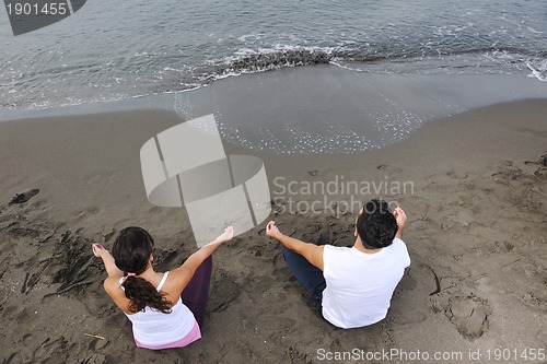 Image of couple yoga beach