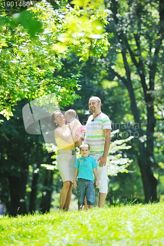 Image of happy young couple with their children have fun at park