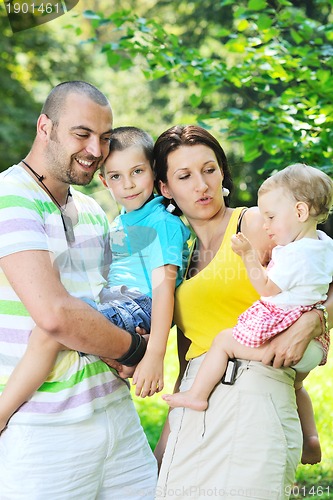 Image of happy young couple with their children have fun at park