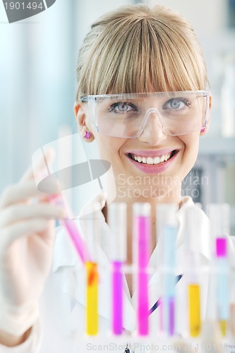 Image of female researcher holding up a test tube in lab