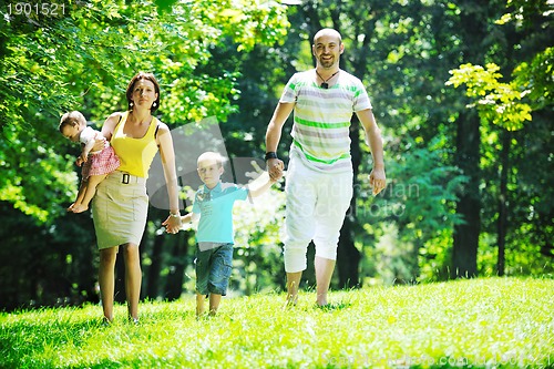 Image of happy young couple with their children have fun at park