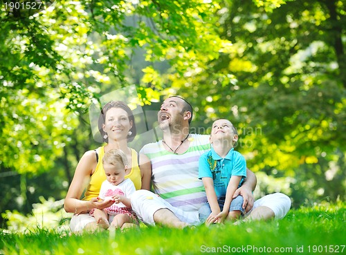 Image of happy young couple with their children have fun at park