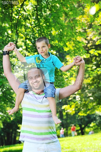 Image of happy father and son have fun at park