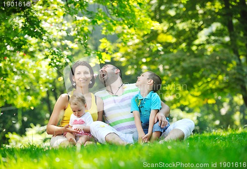 Image of happy young couple with their children have fun at park