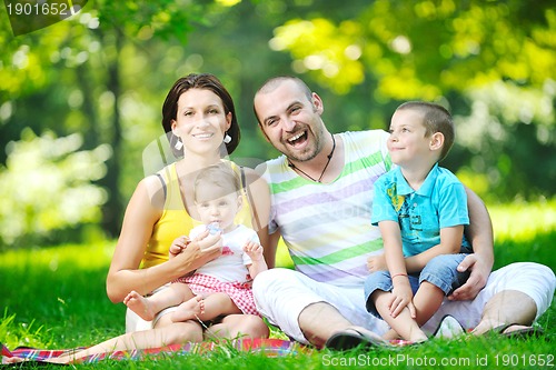 Image of happy young couple with their children have fun at park