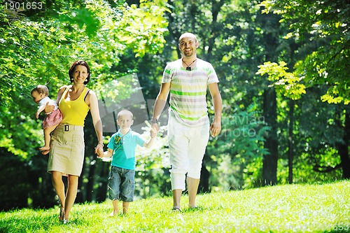 Image of happy young couple with their children have fun at park