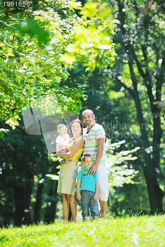 Image of happy young couple with their children have fun at park