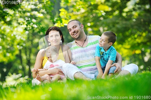 Image of happy young couple with their children have fun at park