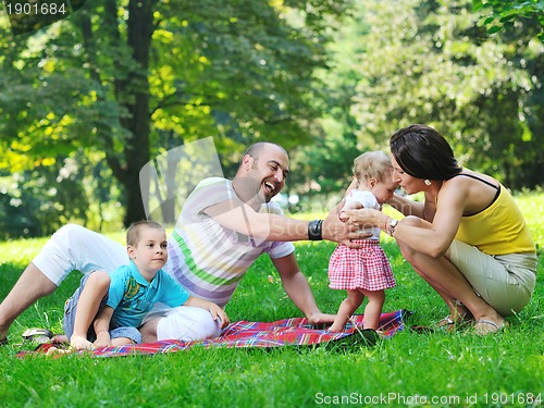 Image of happy young couple with their children have fun at park
