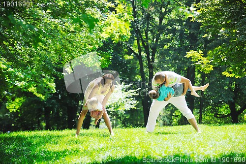 Image of happy young couple with their children have fun at park