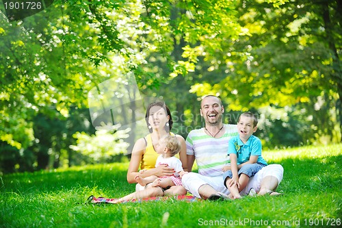 Image of happy young couple with their children have fun at park
