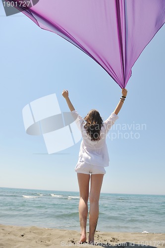 Image of beautiful young woman on beach with scarf