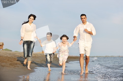 Image of happy young family have fun on beach at sunset