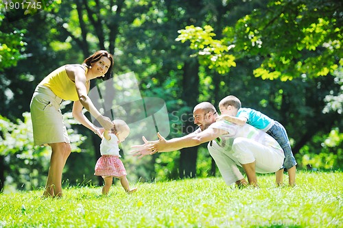 Image of happy young couple with their children have fun at park