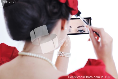 Image of beautiful young woman applying makeup