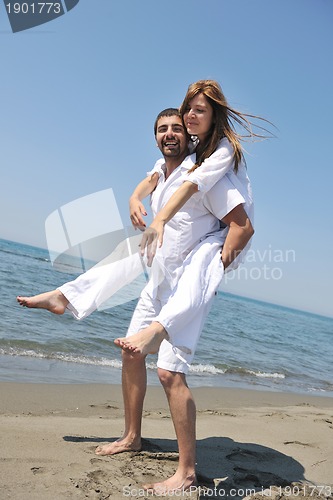 Image of happy young couple have fun on beach